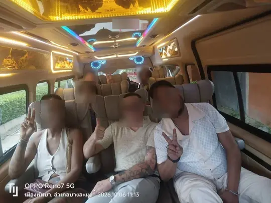 2026년 10월 6일 오전 11시 13분, 촌부리 방라뭉 파타야시에서 황금빛 천장 조명과 파란 LED 링 아래 크림색 가죽 시트의 VIP 캐빈에 앉은 손님들, 몇몇은 브이 사인을 들어 보이고 있다