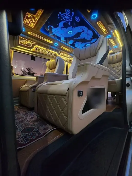 Cream leather captain seats and an LED-lit ceiling inside a Toyota Commuter VIP van